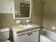 Full bathroom with a vintage tiled vanity, matching tiles, and a shower-tub combo at 506 Byrnes Circle, Johnsonville, SC 29555