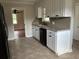 Eat-in kitchen with white cabinets, laminate counters, a black dishwasher, and tile flooring at 506 Byrnes Circle, Johnsonville, SC 29555