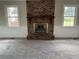 Cozy living room with a brick fireplace as the focal point and two windows that let in natural light at 506 Byrnes Circle, Johnsonville, SC 29555