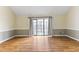 Living room with wood-look floors, neutral walls, and sliding glass doors for natural light at 4350 Spa Dr. # 506, Little River, SC 29566