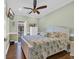 Light-filled bedroom features a ceiling fan, TV, wood floors, and access to an outdoor deck at 6001-O32 S Kings Hwy., Myrtle Beach, SC 29575