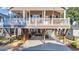 Two-story elevated home featuring an inviting porch, American flag, and covered outdoor living space below at 6001-O32 S Kings Hwy., Myrtle Beach, SC 29575