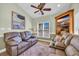 Comfortable living room with leather sofas, a ceiling fan, and a charming beach-themed painting at 6001-O32 S Kings Hwy., Myrtle Beach, SC 29575