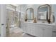 Elegant bathroom with dual sinks, white cabinets, gold framed mirrors, and a glass enclosed shower at 617 Cherry Blossom Dr., Murrells Inlet, SC 29576