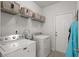 Functional laundry room with a washer, dryer, storage shelves, and exterior door at 617 Cherry Blossom Dr., Murrells Inlet, SC 29576