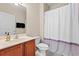 Bathroom featuring a shower with a curtain, wood cabinets, and a white toilet at 6253 Catalina Dr. # 921, North Myrtle Beach, SC 29582