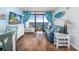 Cozy living room featuring a comfortable blue sofa, wood floors, and sliding glass doors to the balcony at 6804 N Ocean Blvd. # 631, Myrtle Beach, SC 29572