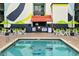 Relaxing outdoor pool area featuring comfortable seating, green umbrellas, and a colorful mural on the building at 6804 N Ocean Blvd. # 631, Myrtle Beach, SC 29572