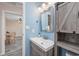 Stylish bathroom with a modern vanity, wood-look storage, and blue accent wall at 6839 Blue Heron Blvd. # 105, Myrtle Beach, SC 29588