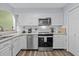 Well-lit kitchen with white cabinetry, stainless steel appliances, and wood-look flooring at 800 9Th Ave. S # R-3, North Myrtle Beach, SC 29582