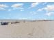 Expansive beach scene with scattered beachgoers enjoying the sun, surf, and pier in the distance at 9820 Queensway Blvd. # 301, Myrtle Beach, SC 29572
