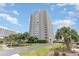 Low-angle view of a high-rise condo building with private balconies and beautiful landscaping at 9820 Queensway Blvd. # 301, Myrtle Beach, SC 29572