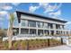 Modern building with a covered patio, outdoor seating, and lush greenery with a palm tree accent at 9820 Queensway Blvd. # 301, Myrtle Beach, SC 29572