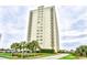 A high-rise condo building featuring private balconies and lush tropical landscaping at 9820 Queensway Blvd. # 301, Myrtle Beach, SC 29572