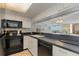 Charming kitchen featuring black appliances, bright cabinets, and tile floors at 9820 Queensway Blvd. # 301, Myrtle Beach, SC 29572