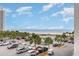 Scenic view from the property overlooking the ocean, beach, palms, and a parking area at 9820 Queensway Blvd. # 301, Myrtle Beach, SC 29572