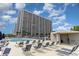 Poolside lounge area with comfortable seating and a large pool, with the condo building in the background at 9820 Queensway Blvd. # 301, Myrtle Beach, SC 29572