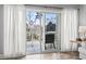 A cozy balcony with outdoor seating is seen through glass doors and white curtains at 1017 World Tour Blvd. # 206, Myrtle Beach, SC 29579