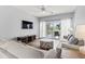 Comfortable living room with neutral tones, laminate flooring, balcony access, and TV at 1017 World Tour Blvd. # 206, Myrtle Beach, SC 29579