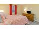 Cozy bedroom features a comfortable bed, a wooden dresser, and bright coral decor at 105 S Ocean Blvd. # 108, North Myrtle Beach, SC 29582