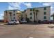 Oceanfront complex with beige stucco and green shutters accented by palm trees and paved parking at 105 S Ocean Blvd. # 108, North Myrtle Beach, SC 29582