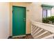 A close-up of a green front door with a small window and natural light at 105 S Ocean Blvd. # 108, North Myrtle Beach, SC 29582