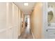 Hallway with white closet doors and wood-look floors leading to a sunny living space at 105 S Ocean Blvd. # 108, North Myrtle Beach, SC 29582