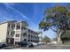 Multi-story condo building with exterior staircases and ample parking on a sunny day at 1058 Sea Mountain Hwy. # 14-203, North Myrtle Beach, SC 29582