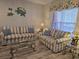Charming living room with striped sofas, glass coffee table, and coastal decor at 1058 Sea Mountain Hwy. # 14-203, North Myrtle Beach, SC 29582