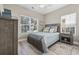 Comfortable bedroom featuring a wooden bed frame, soft blue bedding, and bright natural light from the window at 1604 Cottage Cove Circle, North Myrtle Beach, SC 29582