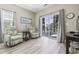 Bright living room with cozy armchairs, wood-look flooring, and a sliding glass door leading to an outdoor space at 1604 Cottage Cove Circle, North Myrtle Beach, SC 29582