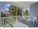 A screened-in porch with white railings, a ceiling fan, and views of the surrounding trees at 1604 Cottage Cove Circle, North Myrtle Beach, SC 29582