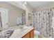 This bathroom features a vanity, commode, floral shower curtain and a large mirror at 1606 Lake Egret Dr., North Myrtle Beach, SC 29582
