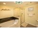 Relaxing bathroom featuring a large tub, glass-enclosed shower, and unique ceiling art at 1625 S Ocean Blvd. # 1109, North Myrtle Beach, SC 29582