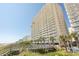 Exterior view of a beachfront high-rise building with private balconies and palm trees at 1625 S Ocean Blvd. # 1109, North Myrtle Beach, SC 29582