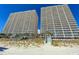 Beautiful view of a tall resort condo featuring multiple stories and balconies facing the sandy beach at 1625 S Ocean Blvd. # 1109, North Myrtle Beach, SC 29582