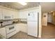 Bright kitchen featuring white appliances, cabinets, and a tile floor, plus an exterior door in view at 1625 S Ocean Blvd. # 1109, North Myrtle Beach, SC 29582