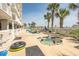 Outdoor pool and jacuzzi area with palm trees, lounge chairs and multiple guests at 1625 S Ocean Blvd. # 1109, North Myrtle Beach, SC 29582
