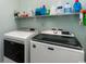 Modern laundry room featuring a new washer and dryer and overhead shelving for storage at 206 Marley Ct., Conway, SC 29526