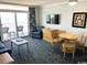 Cozy living area features a sofa, chairs, dining set, dresser, and balcony access at 2201 S Ocean Blvd. # 1603, Myrtle Beach, SC 29577