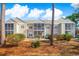 A multi-Gathering home with multiple screened-in balconies surrounded by lush landscaping, enhancing its curb appeal at 2203 Sweetwater Blvd. # 2203, Murrells Inlet, SC 29576