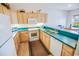A kitchen featuring wood cabinets, modern white appliances, and a complementary countertop at 2203 Sweetwater Blvd. # 2203, Murrells Inlet, SC 29576