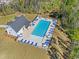 Aerial view of a community pool area with lounge chairs and lush landscaping, surrounded by trees at 3019 Dover Branch Dr., Little River, SC 29566