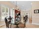 Open-concept dining area with tile floors, plantation shutters, and a view of the modern kitchen at 307 River Rock Ln. # 906, Murrells Inlet, SC 29576
