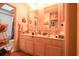 Bathroom featuring double vanity, mirrors, storage, floral wallpaper, and pink carpet at 312 73Rd Ave. N # 15, Myrtle Beach, SC 29572