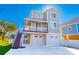 Two-story home on pilings, with covered porch, two-car garage, outdoor stairwell, and located near the beach at 406 26Th Ave N, North Myrtle Beach, SC 29582