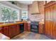 Well-appointed kitchen featuring wood cabinets, gas range, brick accents, and stylish tile flooring at 406 26Th Ave N, North Myrtle Beach, SC 29582