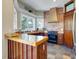 Cozy kitchen features a unique brick accent wall, wood cabinets, and a spacious wooden breakfast bar at 406 26Th Ave N, North Myrtle Beach, SC 29582