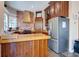 Well-equipped kitchen with stainless steel refrigerator, brick accent, wood cabinets, breakfast bar, and tile flooring at 406 26Th Ave N, North Myrtle Beach, SC 29582
