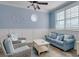 Bright living room featuring a blue sofa, wicker chairs, and natural light from shuttered windows at 406 26Th Ave N, North Myrtle Beach, SC 29582
